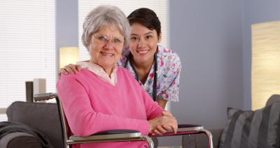 senior woman and caregiver smiling