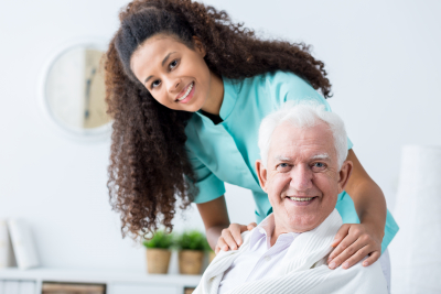 senior man and caregiver smiling