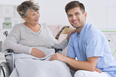 senior woman and caregiver smiling